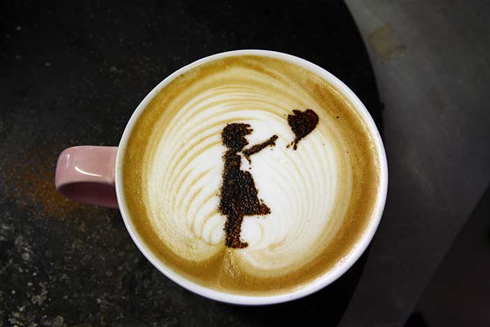 Premium AI Image  Barista makes latte art using latte pen in a beautiful  cup on a picturesque saucer